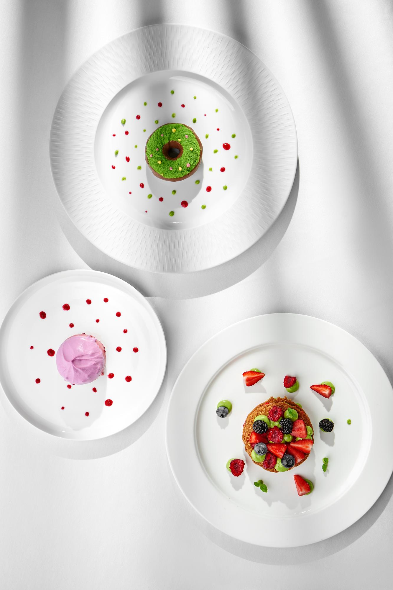 Large editorial shot of plated tasting menu under studio lights